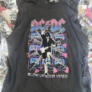 svart tanktop ish med färgglatt ACDC tryck. använt cirka 2 gånger, tycker inte att de passar mig. 