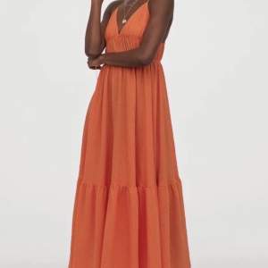 En orange långklänning från H&M i storlek 32 men passar även storlek 34/36 då den är stretchig. 