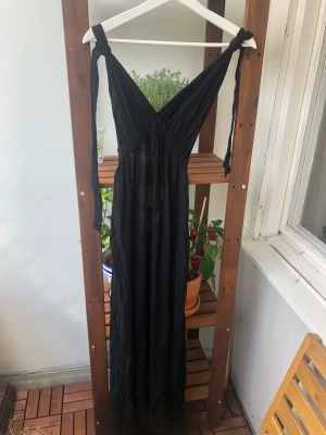 Maxiklänning - Svart lång klänning som man kan knyta i nacken. Väldigt somrig och skulle var perfekt att ha på stranden. Köpt på Urban Outfitters, men är från märket Out From Under