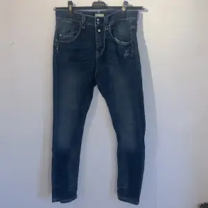Ett par lågmidjade, mörkblåa jeans från JFOUR Australia i storlek S (waist 26)