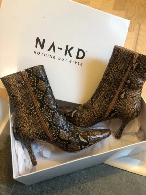 Boots i ormimitation  - Säljer ett par boots i ormimitation.  Använts 1 gång. Som nya