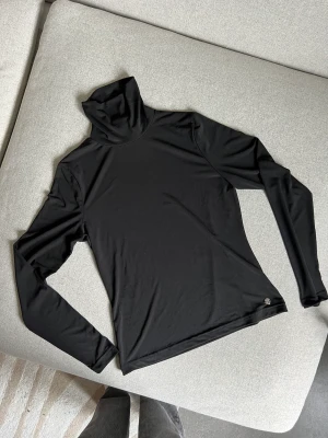 Polotröja  - Svart polotröja i ett väldigt stretchiga material, superskön att ha som baslager, använd ca 5 gånger