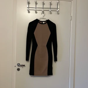 Tight klänning - Figursydd klänning i svart/beige-shellmaterial. Sitter fantastiskt på kroppen! Nyskick