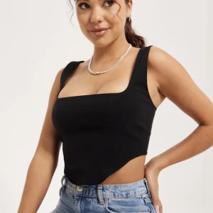 Corset top - Säljer denna helt oanvända Corset top från Nelly då modellen inte passade mig. Passar perfekt till fest eller vardag! Storlek: 34. I material: 77% viskos, 20% polyamid, 3% Elastan. 