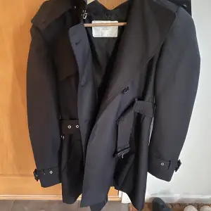Zara, svart trenchcoat med huva och bälte i midjan, aldrig använd, som ny! Storlek: S, Material: Polyester