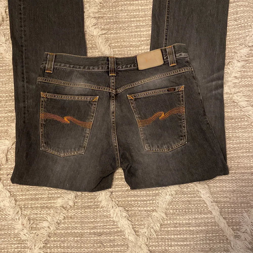 Säljer ett par lågmidjade bootcut Nudie jeans i färgen ”used black” med coola bakfickor i väldigt bra skick med inga defekter💗. Jeans & Byxor.