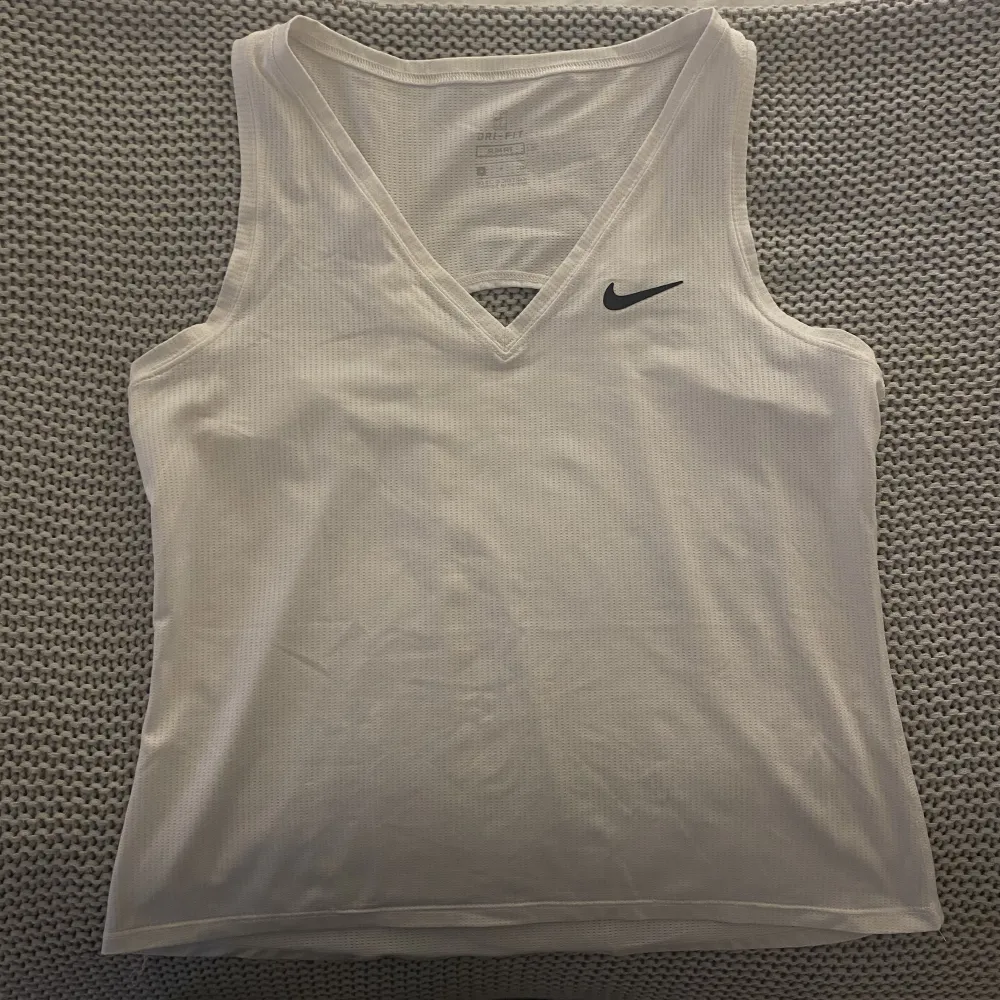 Tennis linne från Nike. Vit med V-ringning. Luftigt och skönt linne, använd fåtal gånger och är i bra kvalitet. Storlek S och färgen vit.. Toppar.