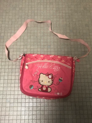 hello kitty axelremsväska  - jättesöt rosa hello kitty axelremsväska💋har en liten fläck på bandet, skriv för bilder🫶
