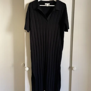 Svart ribbad långklänning - Svart ribbad långklänning som känns rejäl. Storlek XS