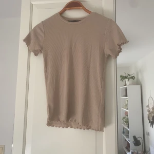 Söt T-Shirt - Superfin beige höst t-shirt med  söta detaljer på kanterna.  Storlek S