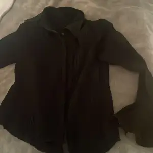 En svart skjortblus med volangarmar. Knappt använd. 