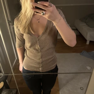 Glittrig blus  - Jag säljer denna super söta guld glittriga blus ❤️ toppen är helt oanvänd och har inga hål, märken osv. Den ser helt ny ut  men har dock tagit av prislappen.  Köpte den i Italien och har inte kommit till användning❤️ köpte för 350kr och säljer för 150kr