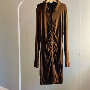 Klänning H&M - Supersnygg lite draperad klänning från H&M dividend, aldrig använd.