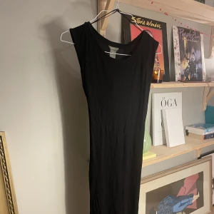 Lång svart strandklänning - Strandklänning eller tunnare sommarklänning använd ett fåtal gånger och i fint skick.   Knyt runt midjan och T-shirt modell 