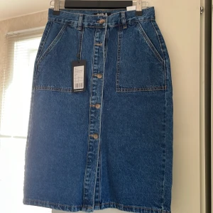 Knälång jeanskjol  - Oanvänd jeanskjol endast legat i garderoben. Kontakta om du har frågor.