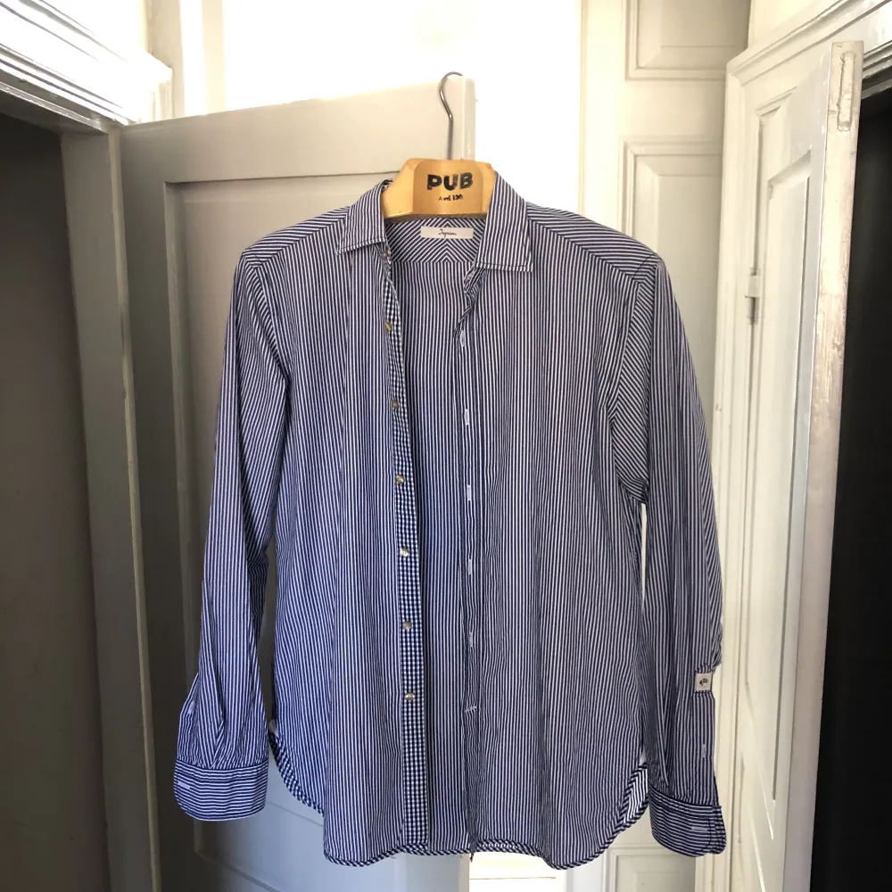 Stilig skjorta med vita och blå ränder från märket Ingram. Använd sparsamt och utan defekter. Nypris: 900 kr. Skjortor.