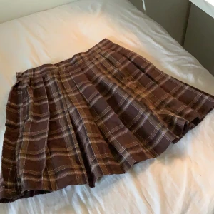 Brun rutig kjol - Rutig kjol i storlek XS/34. Den är i jättebra skick bara att den har börjat noppra 💗