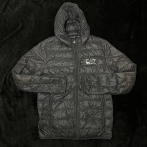 Ea7 armani - En fräsh ea7 armani jacka knappast anvönd har ett litet hål i luvan som är osynlig annars är den i jätte bra skick, den är storlekS men kan öven passa M