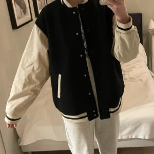 Snygg baseballjacka - Svart baseball/varsityjacka med vita ärmar i läderimitation, sparsamt använd! Passar till allt, sitter snyggt lite oversized på mig som brukar ha xs-s. Köparen står för frakten och betalning sker via swish💕