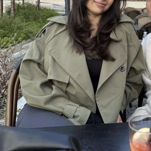 Grön short trench coat  - Grön kort jacka i storlek S, inga defekter alls, säljer då den inte kommer till användning.