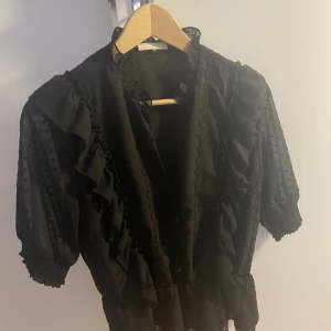 Blus - Blus med volang, sparsamt använd. Storlek S men passar även någon som är M