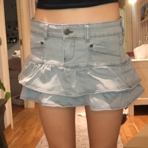 Oanvänd Minikjol Minga Kat Y2K - Grå minikjol från Minga London, Minga Kat Y2K, i grått denimtyg. Oanvänd. Nypris ca 600kr