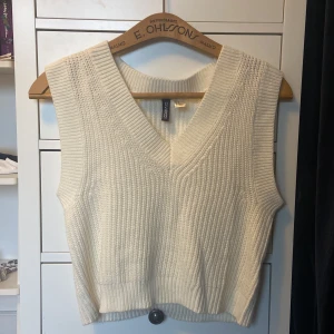 Stickad väst - Superstilig och mysig stickad väst i en krämvit färg. Mycket bra skick och ganska oanvänd. 