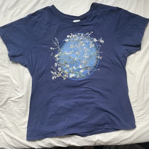Bonsai t-shirt - En fet mörkblå t-shirt med en bonsai-gren med blommor på. Riktigt fet. Passformen ser lote märklig ut när den ligger ner såhär men när den sitter på ser den ut som vilken t-shirt som helst. Inga defekter. Dm för frågor och intresse. Läs min bio