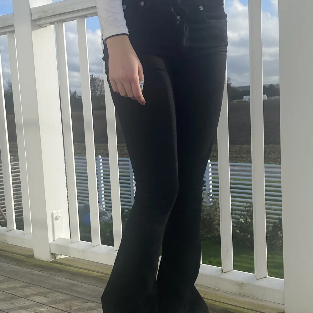 Svarta jeans som är utsvängda, sparsamt använda/. Jeans & Byxor.