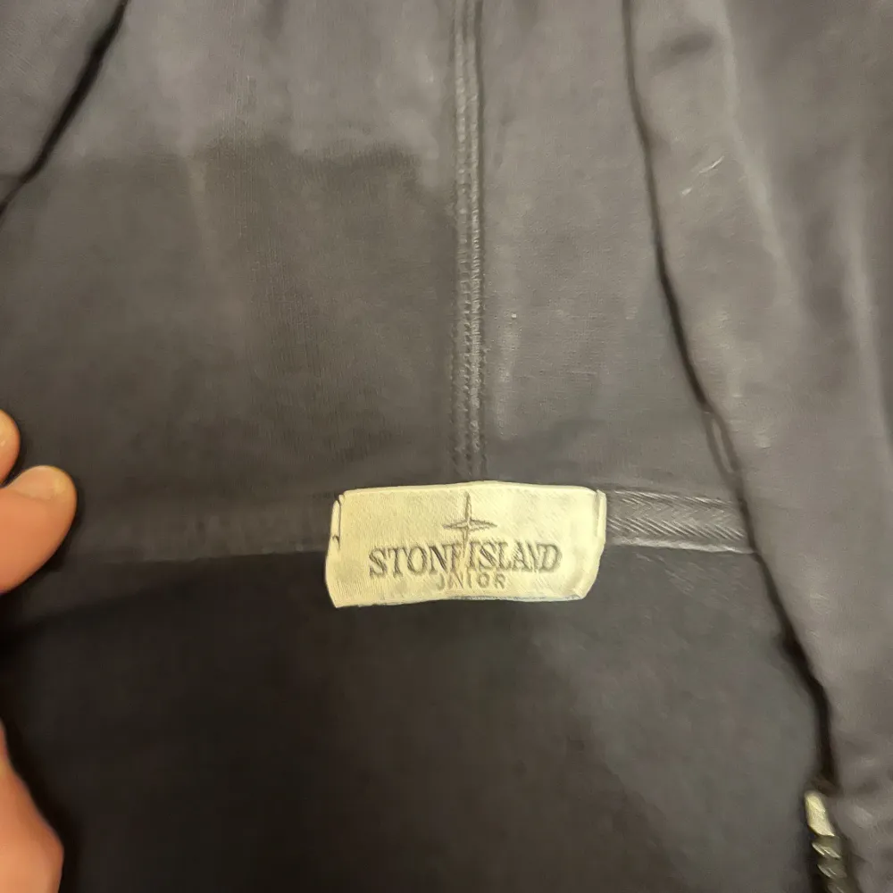 Vi säljer nu denna zip hoodie från Stone Island. Produkten är avsedd för yngre killar där storleken är 12y. Tröjan har använts en del men är fortfarande i ett bra skick. Nypris: Omkring 2000kr. Vårt pris: 500kr. Kontakta oss för fler bilder eller frågor!. Hoodies.