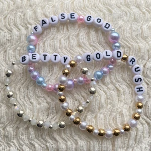 3 Taylor Swift friendship bracelets  - Taylor swift frienship bracelet att behålla för dig själv eller ge bort till andra swifties under the Eras tour. Dessa armband är hemgjorda, elastiska och gjorda för att passa en genomsnittlig handled. För att bevara dem, undvik all kontakt med vatten.