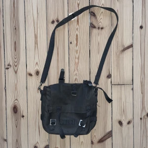 Grå axelremsväska - Grå axelremsväska i canvas tyg. I princip oanvänd! Köpt på plick, har för många väskor så säljer den igen. 20x25 cm