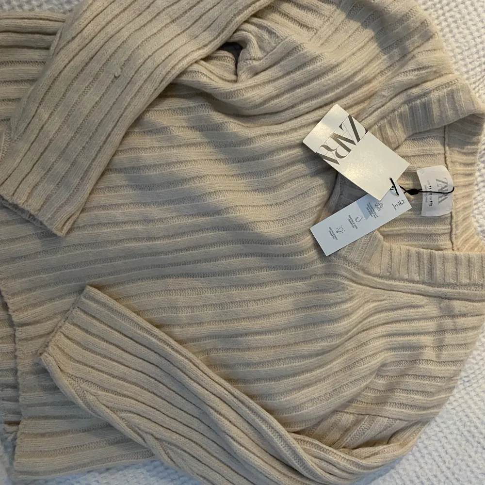 En jättefin oanvänd beige stickad tröja från Zara. Prislappen är kvar. Original pris:265kr. Passar säkert nån storlek större💗💗. Stickat.