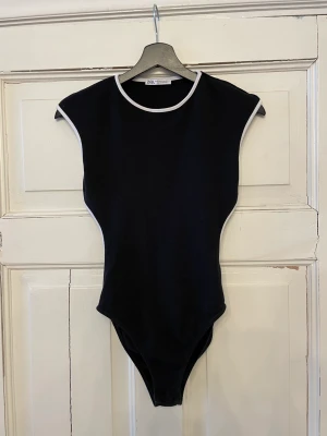 Zara body med öppen rygg  - Perfekt fest body från Zara med öppen rygg och vita kanter. Använd ett fåtal gånger och är i mycket bra skick.  Storlek M 💘