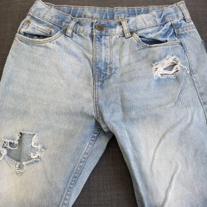 Jeans shorts - Ljusblåa jeans shorts men hål i som passar perfekt nu till sommaren.  Knappt använda så de är i princip nya och fräscha.  Jag står för tvätt och strykning innan leverans. 