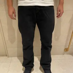 Svarta levi’s jeans modellen är 176 och väger 70 kg