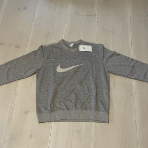 Vintage Nike sweatshirt  - En grå sweatshirt som har den äldre looken. Säljer på grund av fel storlek. Är storlek M men sitter perfekt som S