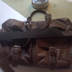 Väska från piccard - Brun fin väska ser lite sliten ut Mycket fack Mått Längd 50cm Höjd 33cm Kostade ny 800kr Nu 400kr använd 2ggr