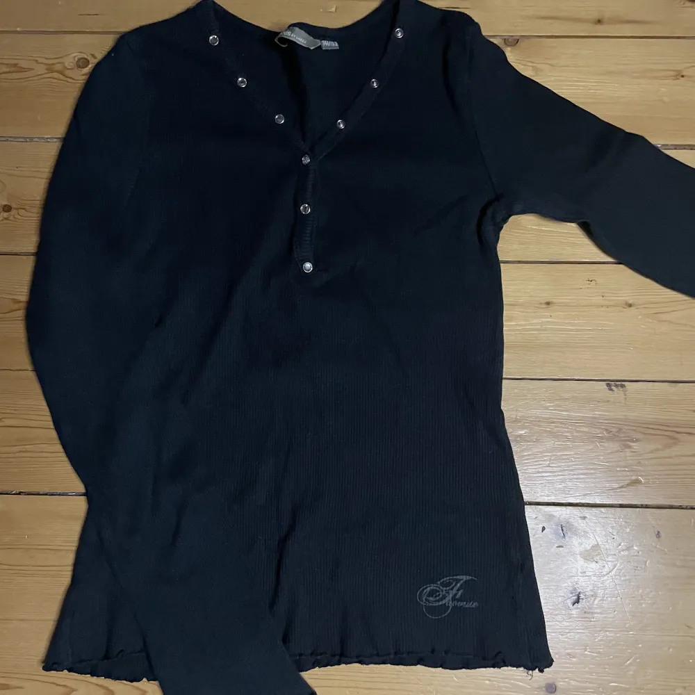 Långärmad svart tröja med knappar. Ribbat tyg och ”ruffled” sömmar vid ärmar och nedre kant. Jag tycker den är jättefin men den passar tyvärr inte mig längre, därför säljer jag den!. Toppar.
