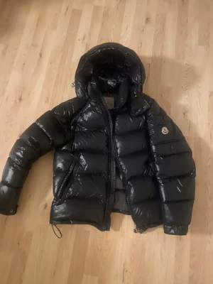 Moncler Maya strl 4 - Säljer min Moncler Maya som är i nyskick och som inte har några skador. Jackan är i färgen Svart och storlek 4, typ L. Har tagsen kvar från jackan som NFC-tag som man kan scanna med telefonen.