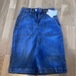Jeans kjol  - Helt ny Jeans kjol med prislapp kvar. Kjolen har en slits i mitten som kanske inte syns på bilden