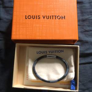 Ett stiligt 1:1 Louis Vuitton-armband i blått. Sprillans nytt, inga tecken på användning. Låda och dustbag medföljer. Metallen är silverfärgad. Passar handleder under 20 cm i omkrets