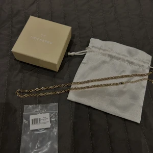 MOCKBERG DARLING NECKLACE - Mockbergs darling necklace i guld. Nyskick då den endast är använd 1 gång. Halsbandet är tillverkat i rostfritt stål och en 18K guld PVD-beläggning vilket gör att den inte tappar färg och dessutom vattentålig. Förlängninskedjan går att ta av. Nypris 699kr