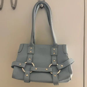 Axelväska - Blå rymlig väska med silvermedaljer, aldrig använd.