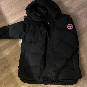 Canada goose vinterjacka - Sparsamt använd vinterjacka. Inga defekter förutom ett litet hål se bild nr 2, det syns knappt men går att fixa enkelt om man vill det. Herr modell