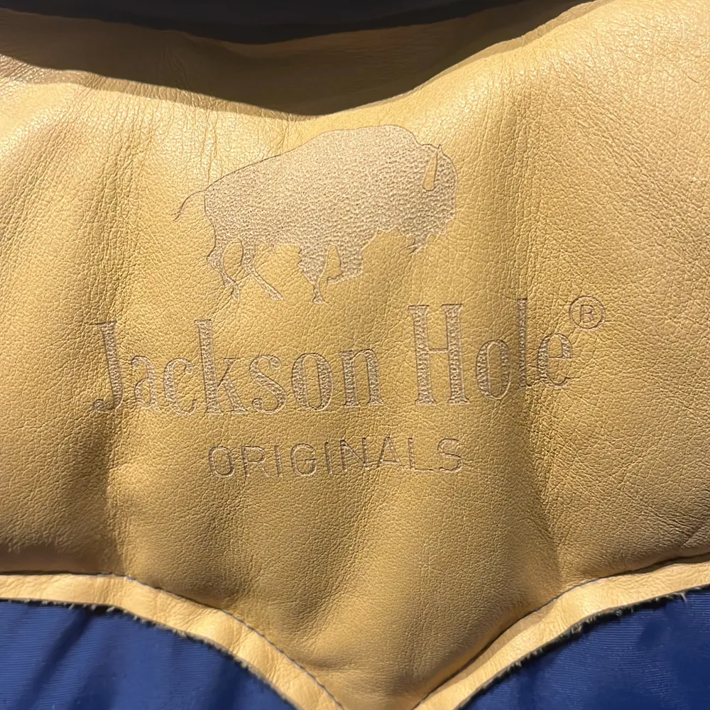 Bästa original dunvästen från Jackson Hole med ok i äkta läder. Snygg , varm och slitstark är kännetecknet för Jackson Hole. Märket präglat bak i skinnet på oket. Två praktiska fickor med dragkedjor på insidan. Storlek 140/146 ca 10-12 år. Nypris 2995kr. Övrigt.
