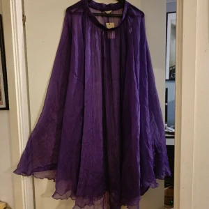 Vacker lila, genomskinlig kjol - Lång kjol, lila och genomskinlig. Aldrig använd. Ca 80 cm i midjemått, ca 120cm lång. Resår i midjan.