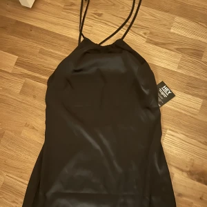 Klänning - Säljer en satin klänning från Nelly aldrig använd strl L 150kr 