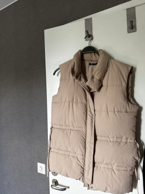 Väst  - Väst i beige färg ungefär. 