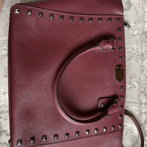 Äkta Michael Kors väska  - Köpt 2015 och har nu inte användts på flera år. I gott skick utöver lite tärd där ena bandet fästs vilket ses på sista bilden. Den håller dock bra. 